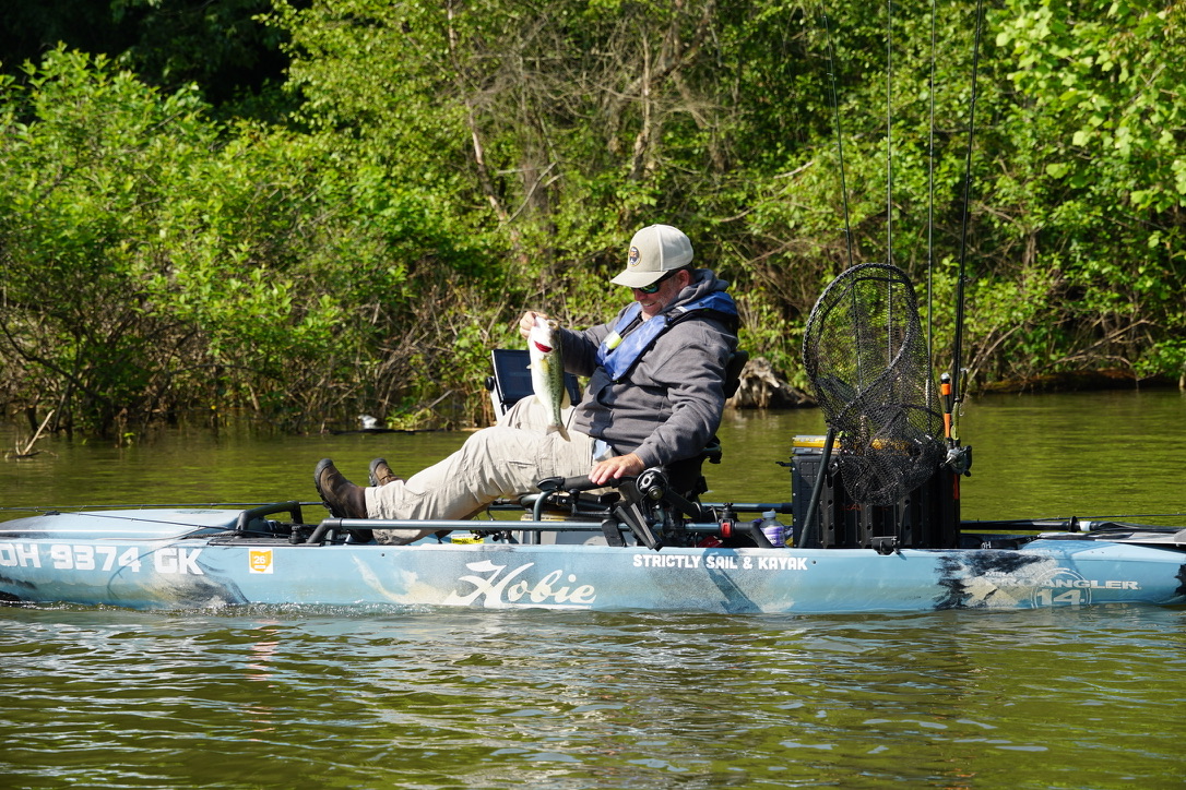 CKF angler holding a bass from his kayak