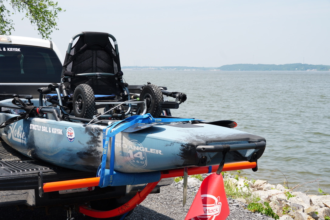 Fishing kayak rigged and ready beside the lake