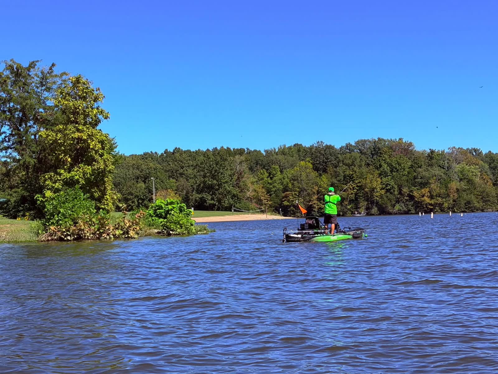 Angler standing and casting from a green kayak at Rocky Fork Lake